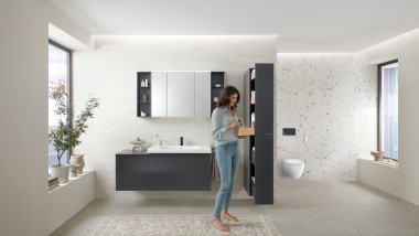 Woman opens tall cabinet with lots of storage space in bathroom